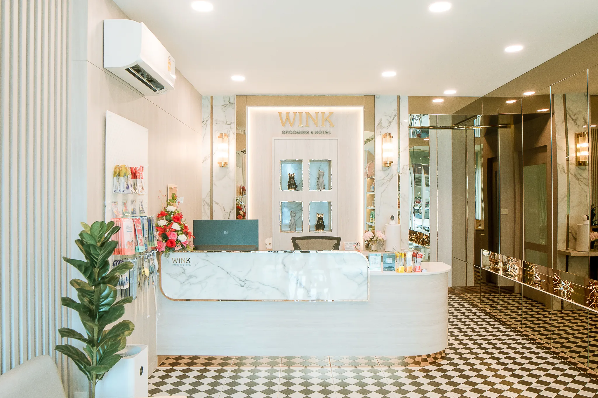 เคาน์เตอร์ต้อนรับหินอ่อนขาว ป้าย WINK GROOMING & HOTEL สีทอง ผนังกระจกเงา พื้นกระเบื้องลายหมากรุก